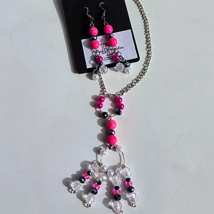 A beaded necklace and matching drop earrings displayed on a black card. The jewelry features bright hot pink beads, clear faceted crystal beads, and small black beads on a silver-tone chain.