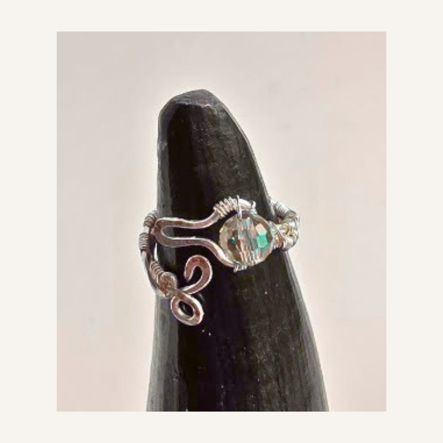 Shop a handmade adjustable silver-plated wire wrapped ring featuring a sparkling faceted crystal bead and artistic snake-inspired design. Made in Alberta.