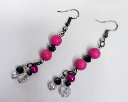 A pair of handcrafted boho style earrings with pink wood beads, black and pearl vintage beads, and rhinestones, made with steel hooks.