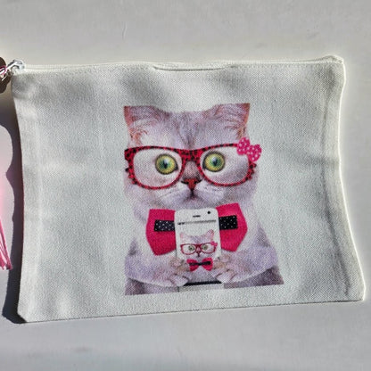 A white canvas zippered pouch featuring a printed graphic of a gray cat wearing red glasses, a red polka-dot bow tie, and holding a phone.