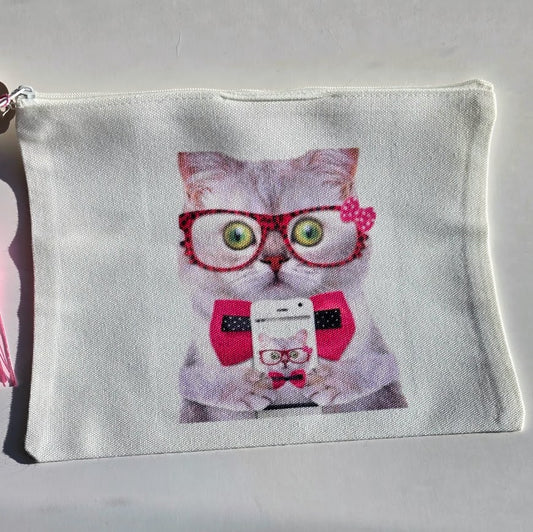 A white canvas zippered pouch featuring a printed graphic of a gray cat wearing red glasses, a red polka-dot bow tie, and holding a phone.