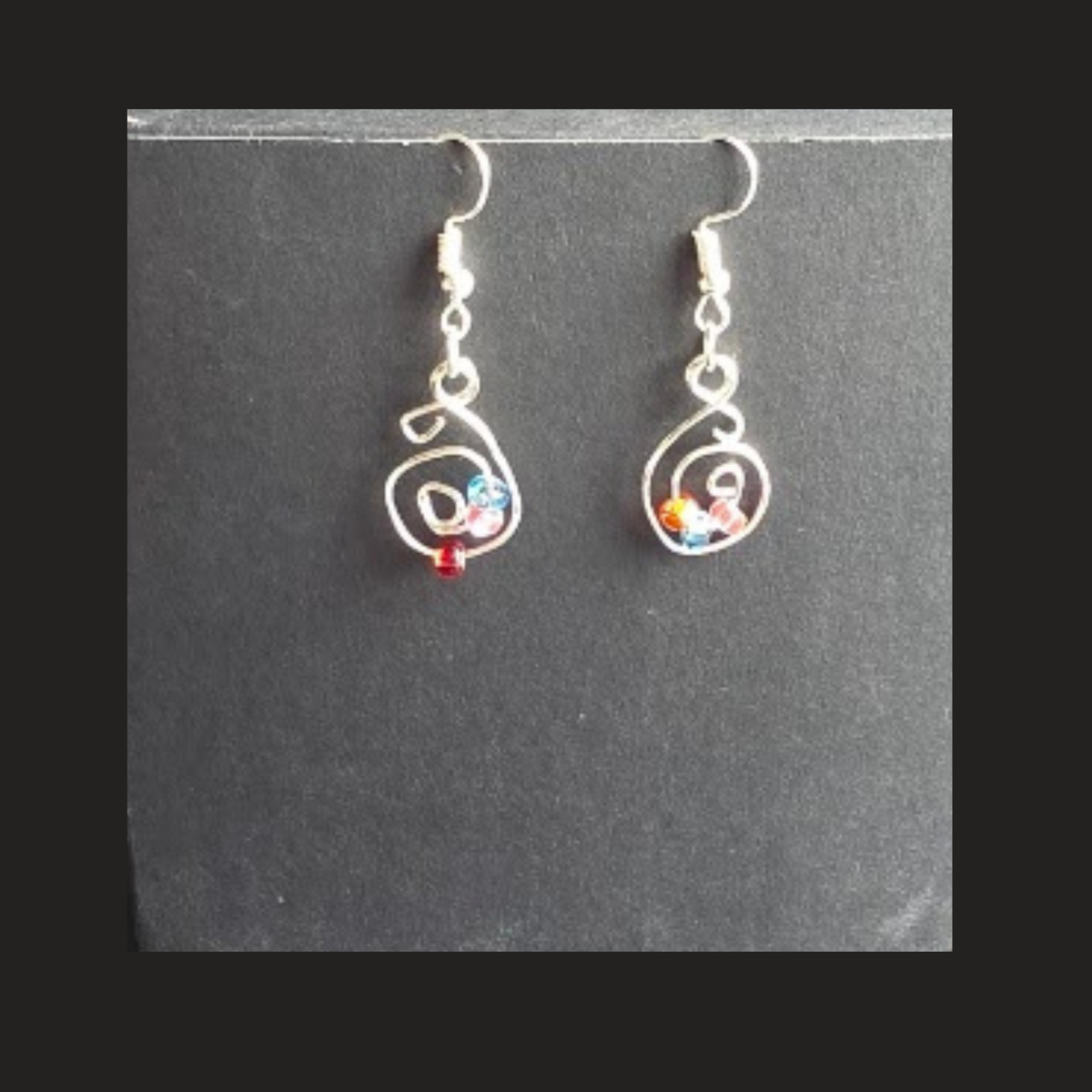 Shop handmade silver-tone spiral dangle earrings with colourful bead accents. Lightweight handcrafted earrings made in Alberta, Canada.