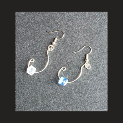A pair of silver-plated dangle earrings with curved wire hooks, small decorative charms, and cube-shaped beads, displayed on a textured gray background.
Shop handmade silver-plated wire dangle earrings .
Lightweight handcrafted jewelry made in Alberta, Canada.